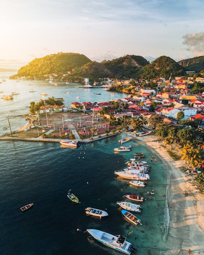 A stunning aerial view of a vibrant bay in Guadeloupe with boats and colorful buildings.