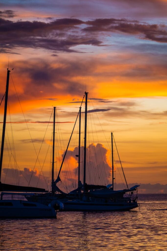 Stunning view of boats silhouetted against a vibrant sunset in Baie-Mahault, Guadeloupe.